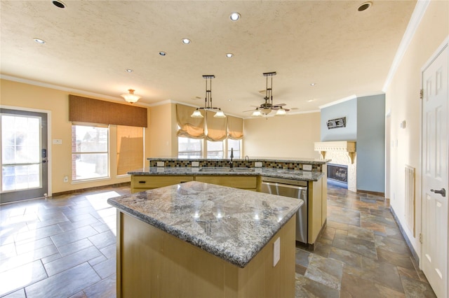kitchen with a sink, stainless steel dishwasher, ornamental molding, and a kitchen island with sink