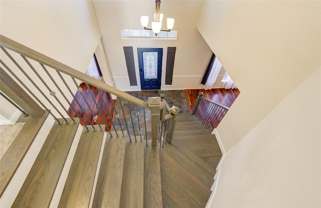 foyer entrance with stairs, a high ceiling, and wood finished floors