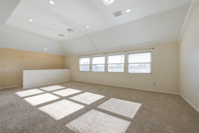 unfurnished room featuring lofted ceiling, visible vents, recessed lighting, light carpet, and baseboards