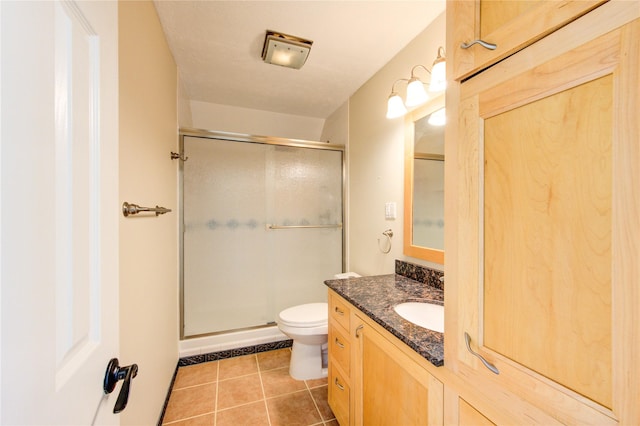 full bath with tile patterned floors, toilet, a stall shower, and vanity