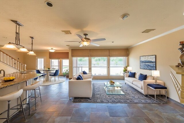 1016 Applewood Dr, Friendswood, TX 77546 - living area featuring crown molding, stone tile flooring, a ceiling fan, and baseboards