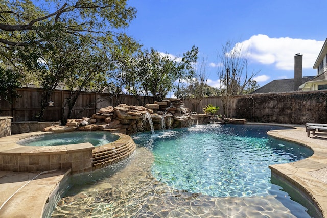 view of pool with a pool with connected hot tub and a fenced backyard