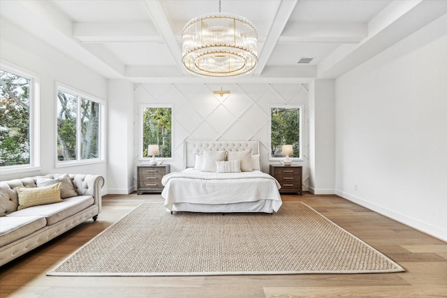 bedroom with a chandelier, coffered ceiling, wood finished floors, and baseboards