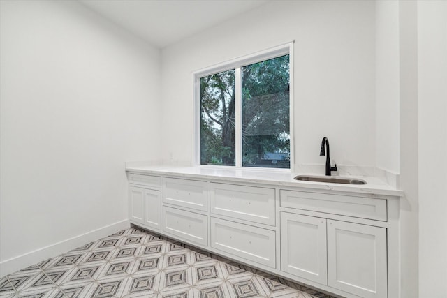 interior space featuring baseboards and a sink