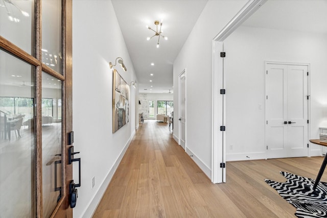 hall with light wood-style floors, baseboards, and recessed lighting