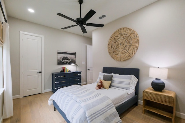 bedroom featuring a ceiling fan, baseboards, visible vents, and light wood finished floors