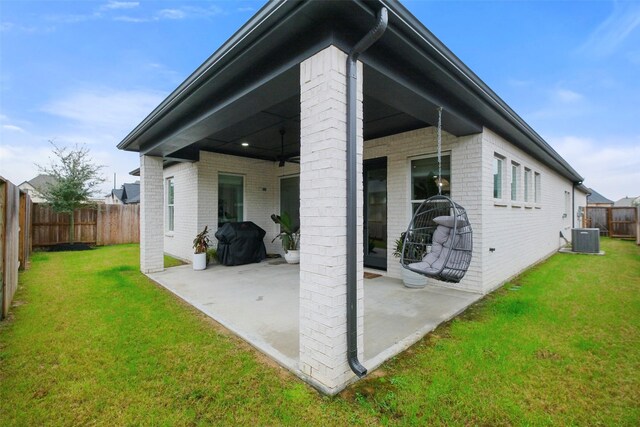 rear view of property with a patio area, a lawn, brick siding, and central air condition unit