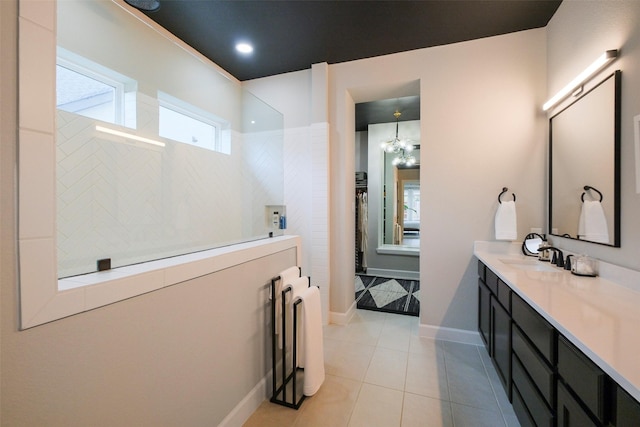 full bathroom featuring a notable chandelier, tile patterned floors, vanity, baseboards, and walk in shower