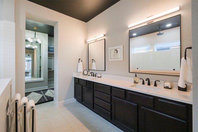 full bathroom featuring double vanity, tile patterned flooring, a sink, and baseboards