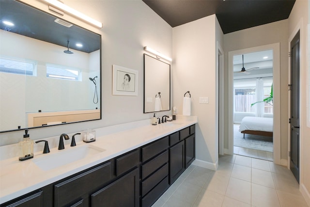 bathroom with a sink, double vanity, tiled shower, and tile patterned flooring