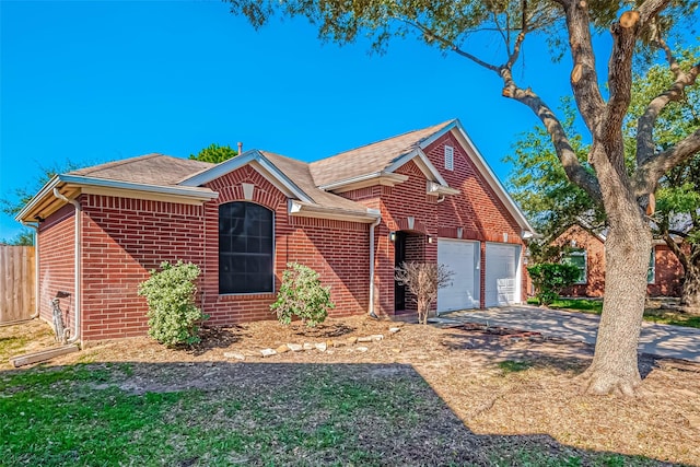 view of front of property with driveway, a garage, fence, and brick siding