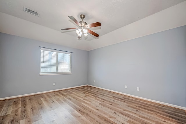 spare room with a ceiling fan, baseboards, visible vents, and wood finished floors