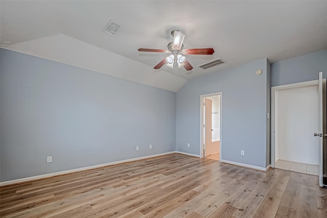 unfurnished bedroom featuring lofted ceiling, light wood-style floors, baseboards, and visible vents