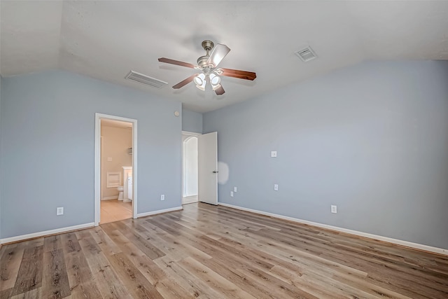 unfurnished bedroom featuring lofted ceiling, baseboards, visible vents, and light wood finished floors