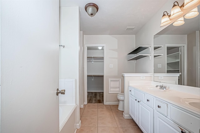 bathroom with double vanity, visible vents, toilet, a sink, and tile patterned floors