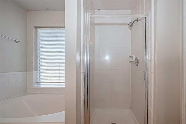 full bathroom with a stall shower and a bath