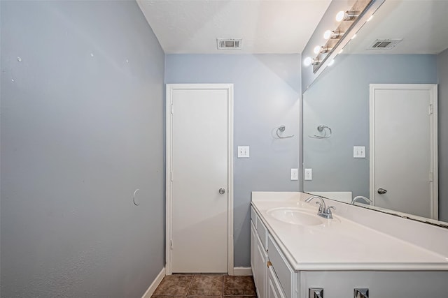 bathroom featuring baseboards, visible vents, tile patterned flooring, and vanity