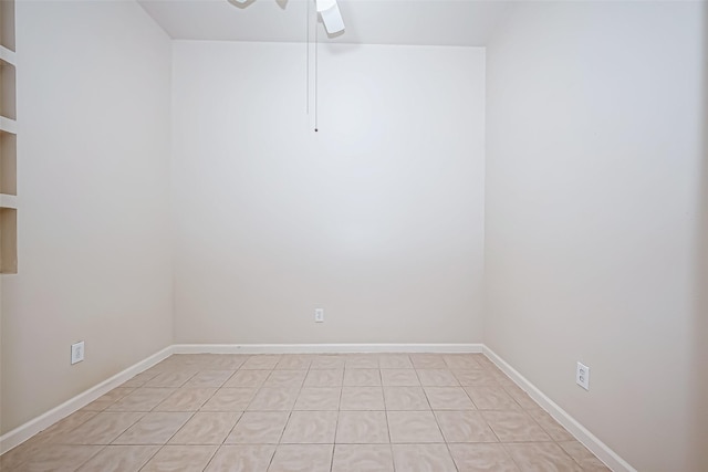 spare room featuring a ceiling fan and baseboards