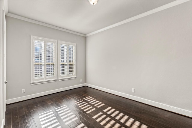 empty room with ornamental molding, dark wood-style flooring, and baseboards