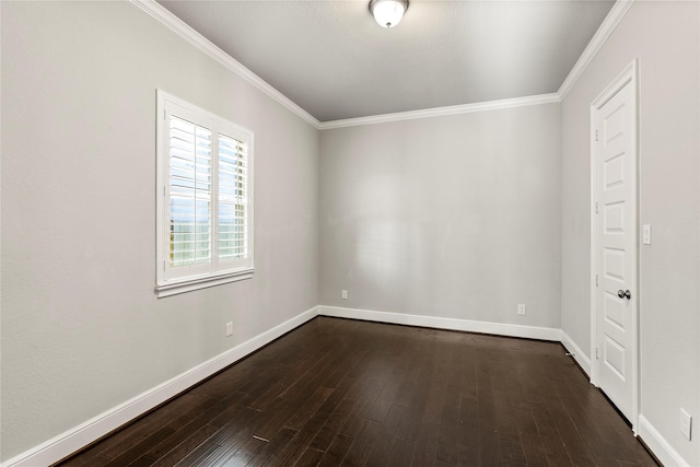 spare room featuring dark wood-type flooring, crown molding, and baseboards