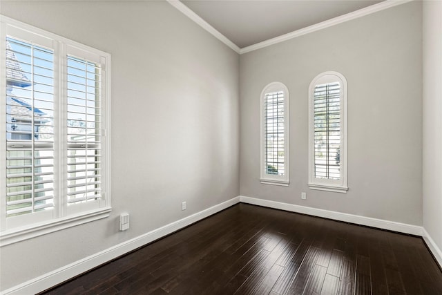 empty room featuring crown molding, dark wood-type flooring, and baseboards