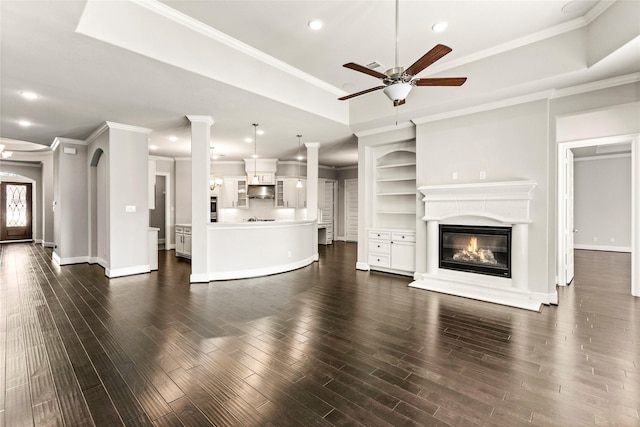 unfurnished living room featuring dark wood-type flooring, recessed lighting, a glass covered fireplace, and baseboards