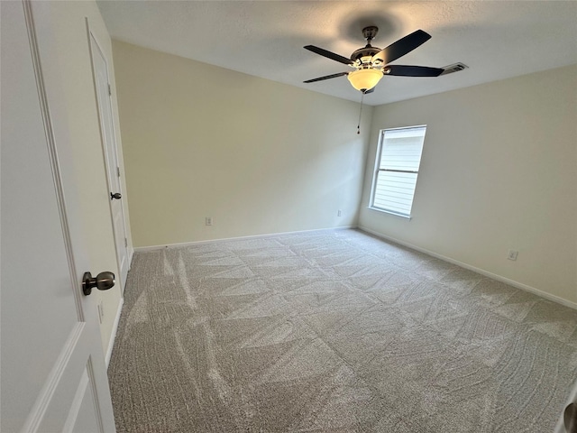 unfurnished room with light carpet, ceiling fan, a textured ceiling, and baseboards