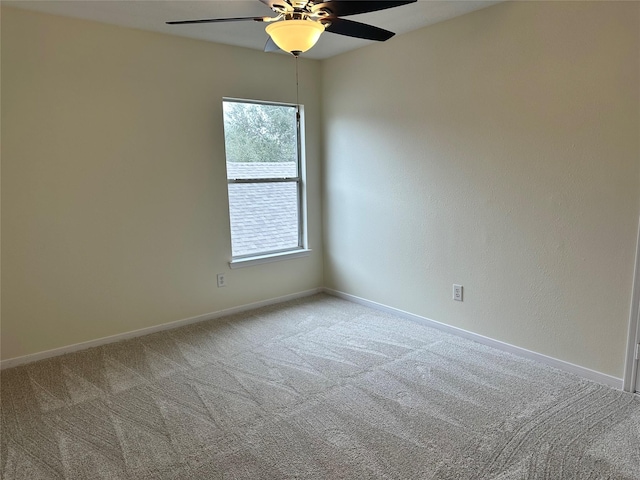 carpeted empty room with ceiling fan and baseboards