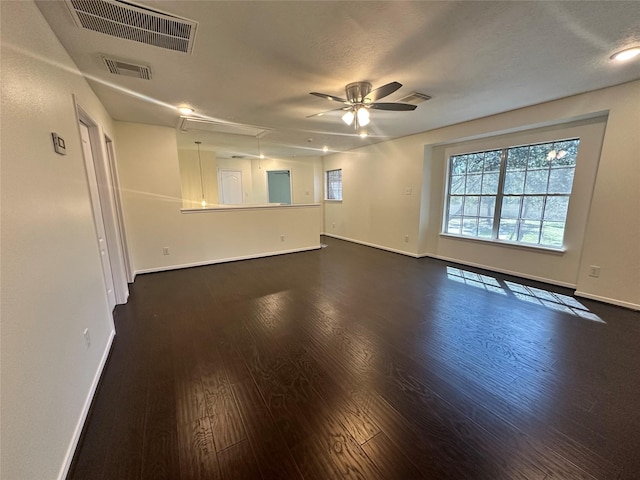 unfurnished room with visible vents, dark wood-style flooring, and attic access