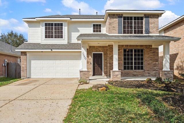 traditional home with concrete driveway, a garage, brick siding, and covered porch