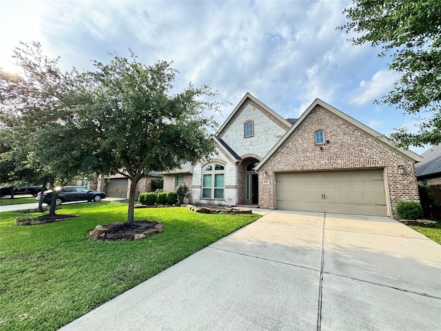 view of front of property featuring a garage, brick siding, driveway, stone siding, and a front yard