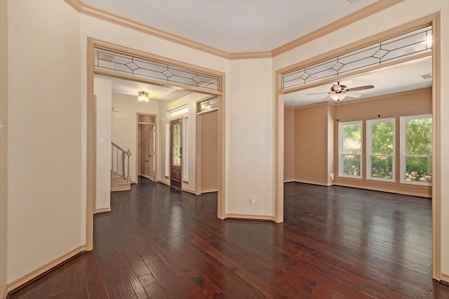 empty room featuring baseboards, a ceiling fan, stairway, ornamental molding, and dark wood-style flooring