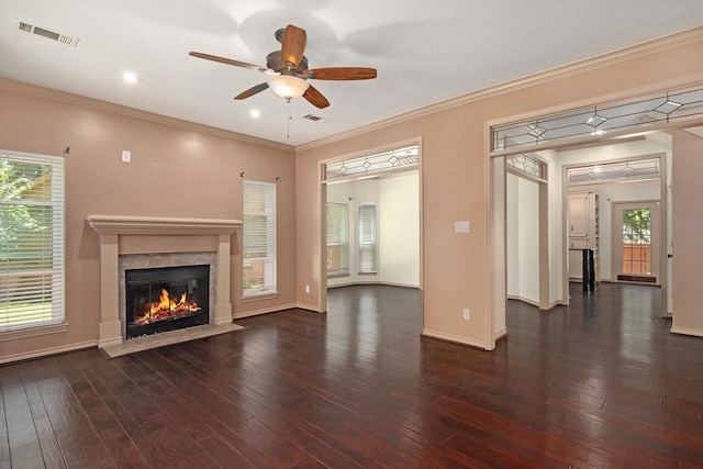 unfurnished living room with crown molding, wood-type flooring, visible vents, a premium fireplace, and baseboards