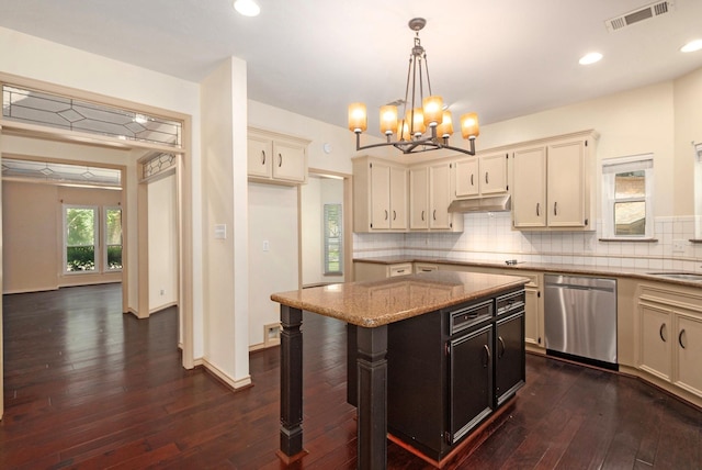 kitchen with light stone counters, dark wood-style flooring, tasteful backsplash, visible vents, and stainless steel dishwasher