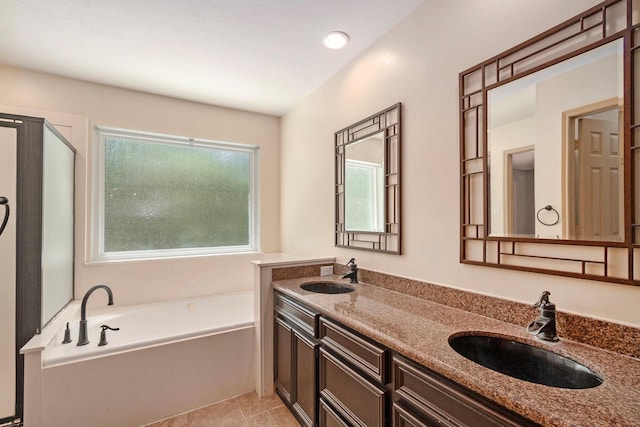 bathroom featuring a garden tub, double vanity, a sink, and a shower with door