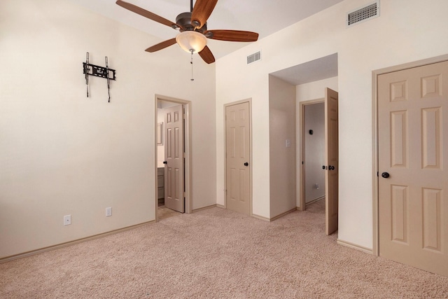 unfurnished bedroom featuring light carpet, connected bathroom, visible vents, and baseboards