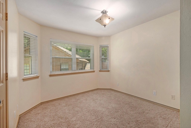 spare room featuring carpet flooring and baseboards