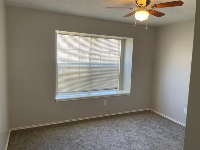 carpeted spare room featuring a textured ceiling, ceiling fan, and baseboards