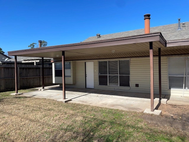 back of house featuring a yard, a patio area, fence, and roof with shingles