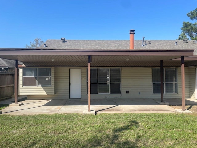 back of property featuring a patio, a yard, and roof with shingles