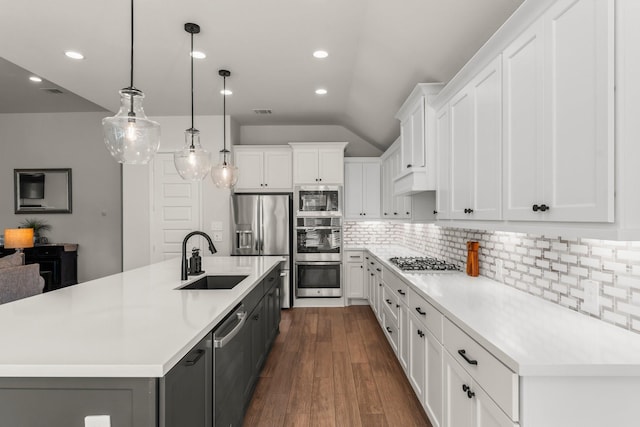 kitchen with dark wood finished floors, appliances with stainless steel finishes, light countertops, and a sink