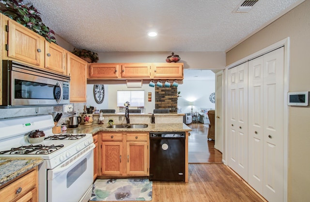 kitchen with a sink, visible vents, white gas range oven, dishwasher, and stainless steel microwave