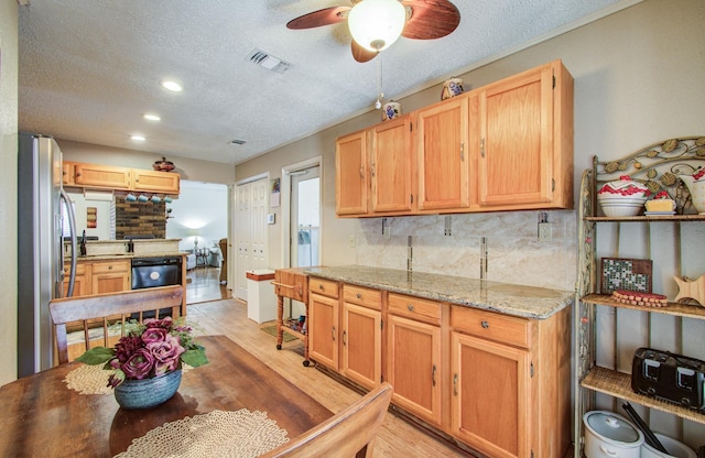 kitchen featuring tasteful backsplash, visible vents, light wood-style flooring, freestanding refrigerator, and a textured ceiling