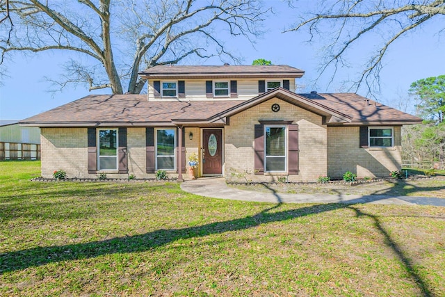 view of front of property featuring brick siding and a front yard