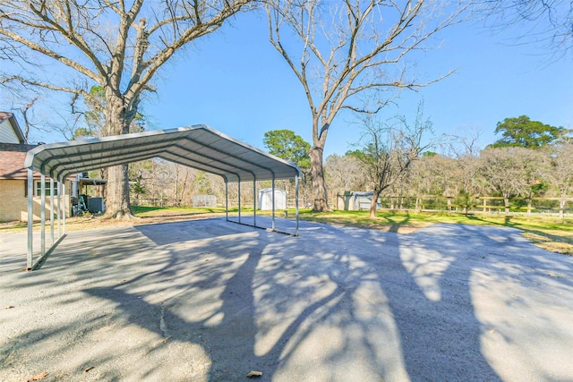 surrounding community featuring an outbuilding, a shed, aphalt driveway, and a detached carport