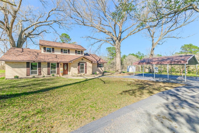 view of front of home featuring a detached carport, brick siding, and a front lawn