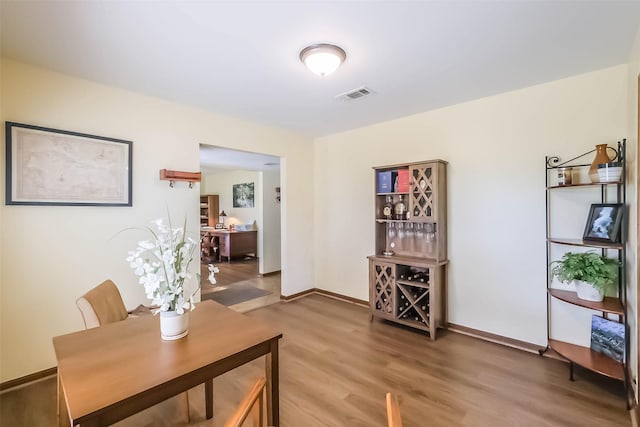 dining room featuring light wood-style floors, baseboards, and visible vents