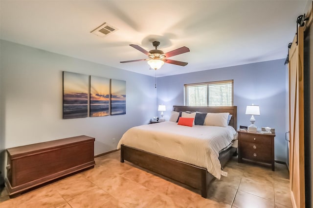 bedroom featuring light tile patterned floors, visible vents, a barn door, ceiling fan, and baseboards