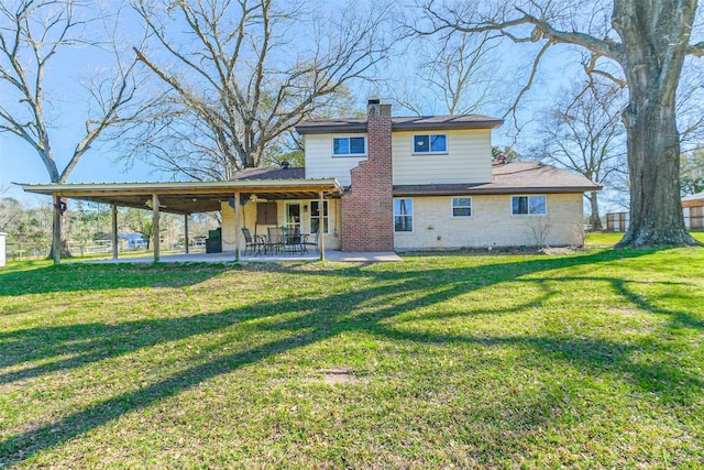 back of property with a patio, a chimney, and a lawn