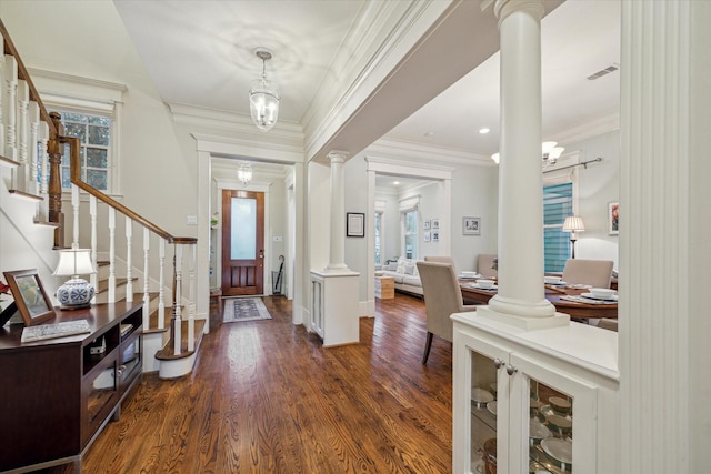 foyer entrance featuring dark wood-style floors, visible vents, stairway, and ornate columns